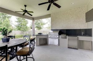 Outdoor kitchen area has most everything you need to make a complete meal. All the appliances are stainless steel. There is a tv for entertainment as you cook.